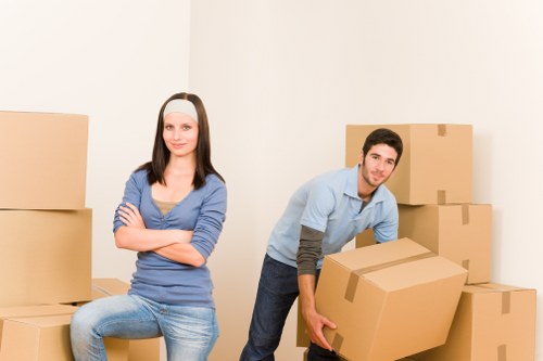 Professional movers carrying furniture through a London property